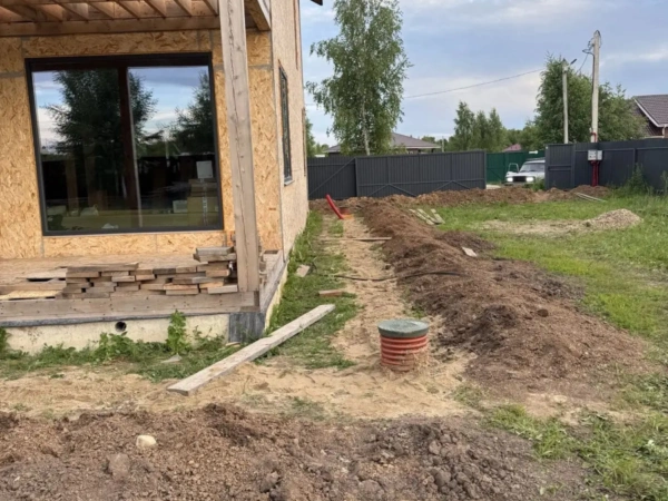Ревизионный колодец канализации у каркасного дома на участке